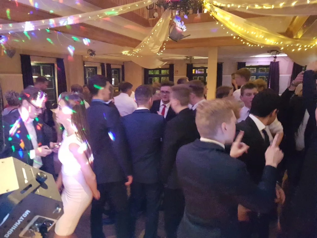 Abiball-Gäste in Anzügen auf der Tanzfläche