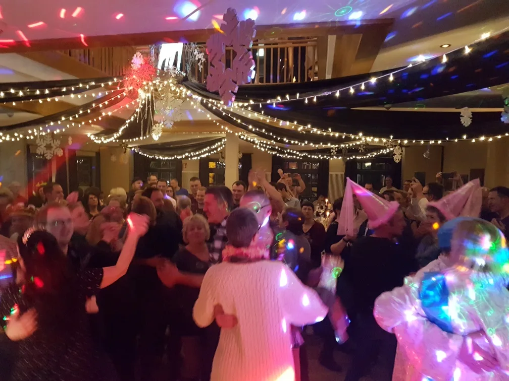 Karnevalsfeier mit Partyhüten unter Lichterketten