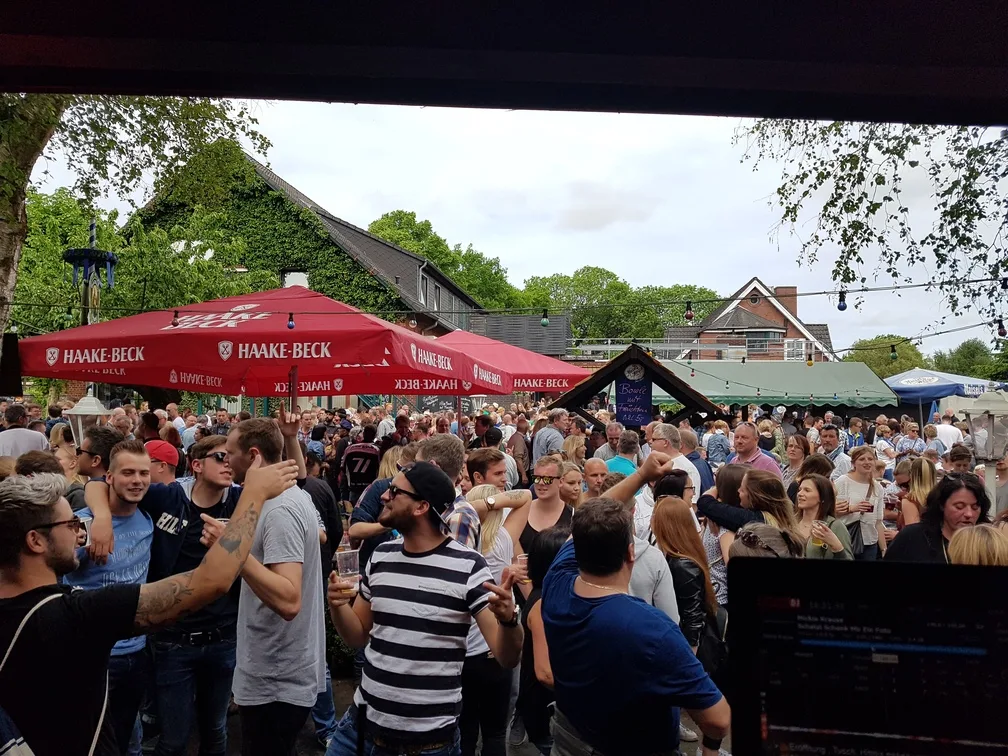 Open-Air-Fest mit Sonnenschirmen und feiernden Gästen