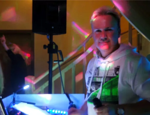 DJ Axel Schmiech mit Mikrofon neben dem Lautsprecher