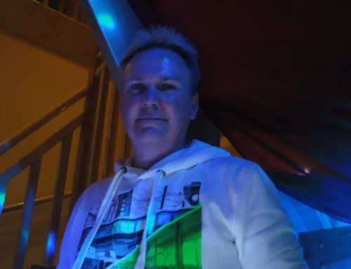 DJ Axel Schmiech bei blauem Licht auf der Treppe